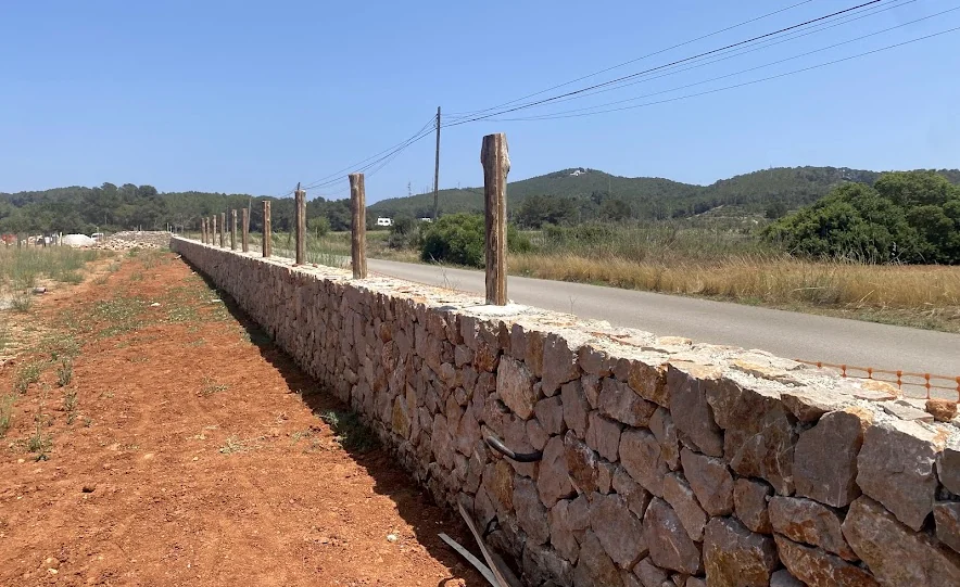 Stone boundary wall alongside a rural road